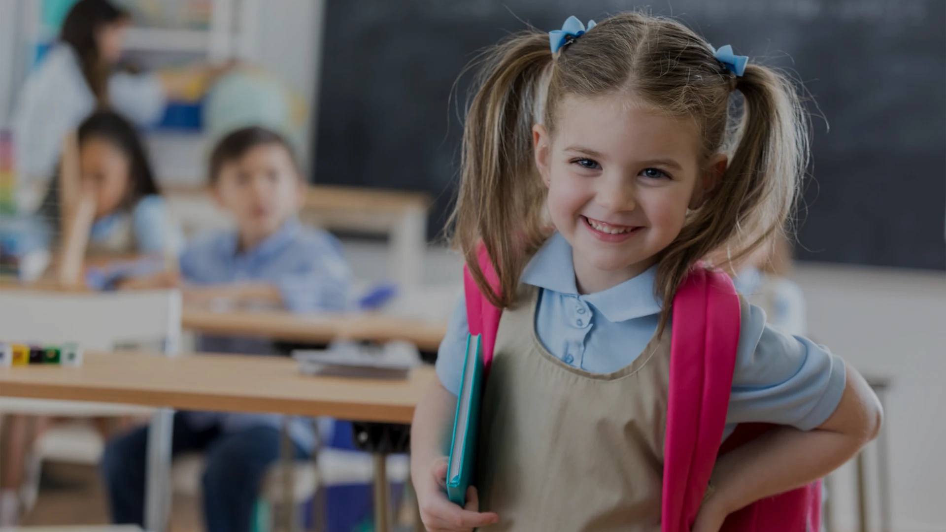Niña en el aula con mochila rosa